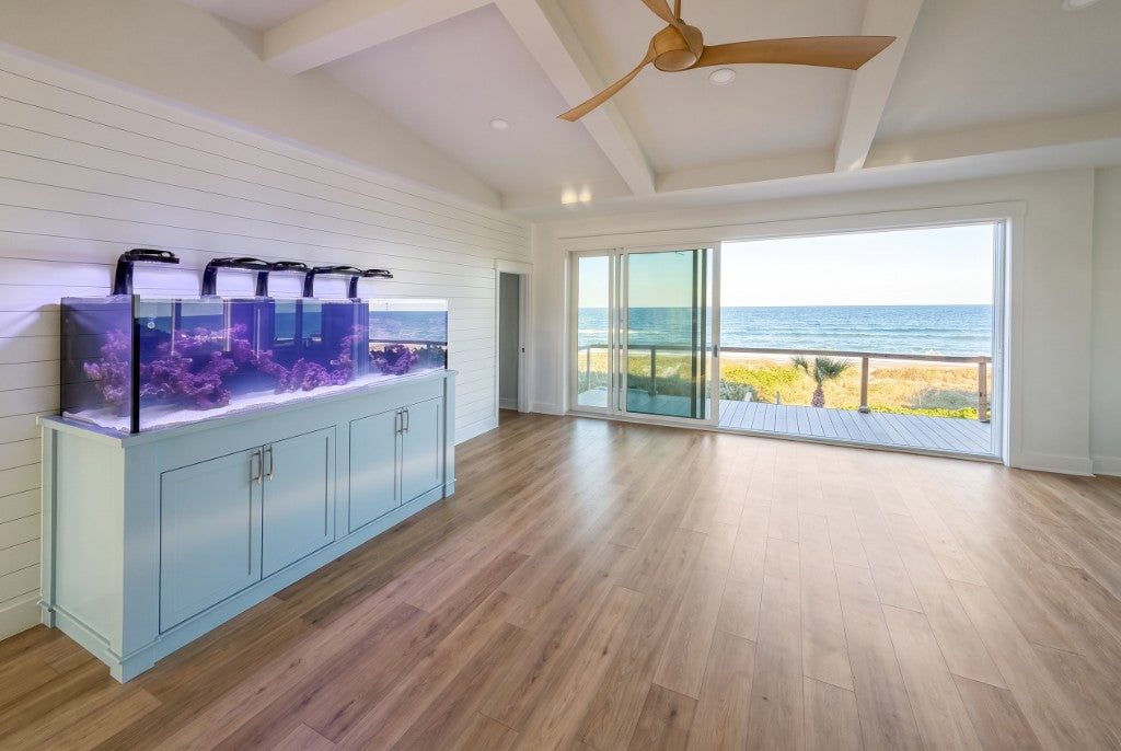 Custom aquarium with blue cabinetry in an oceanfront living space