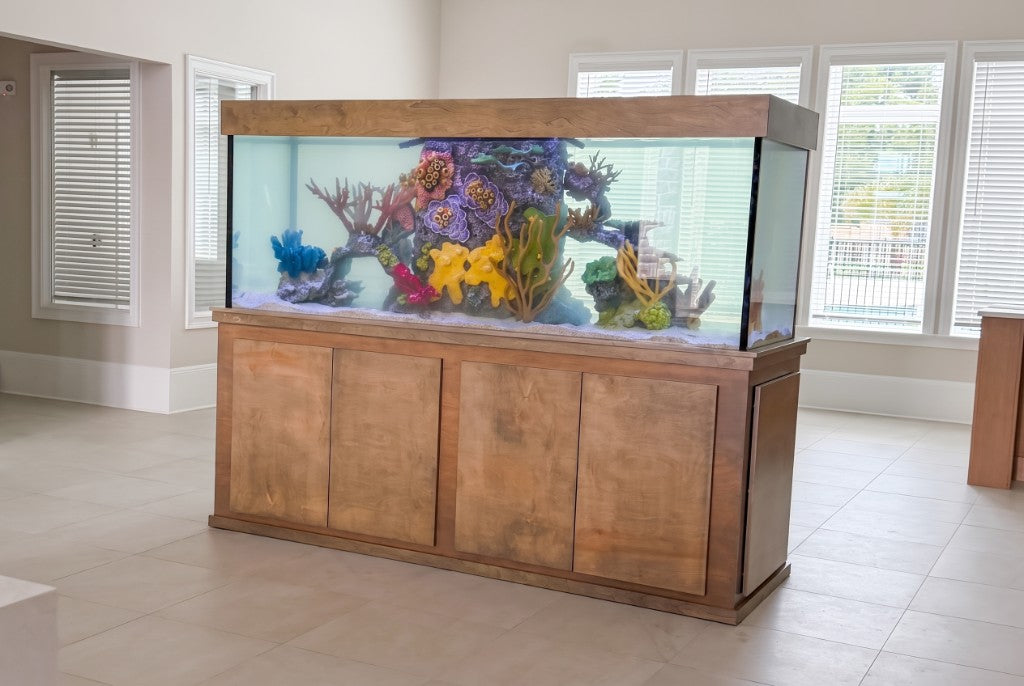 Custom aquarium with walnut cabinetry and a colorful coral reef insert