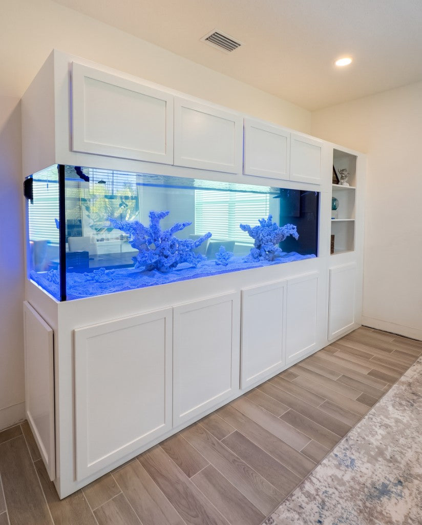 Large custom aquarium integrated into floor-to-ceiling white cabinetry